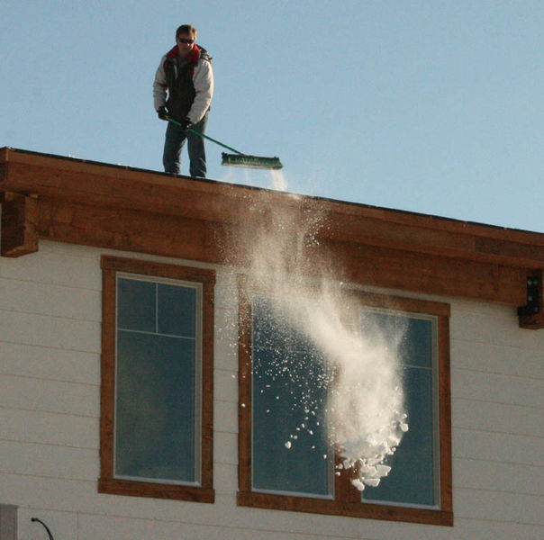 Brushing snow off the roof. Photo by Dawn Ballou, Pinedale Online.