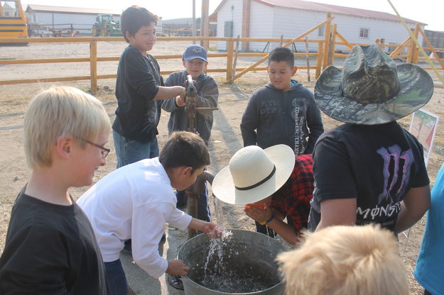 Tasting the well water. Photo by Dawn Ballou, Pinedale Online.