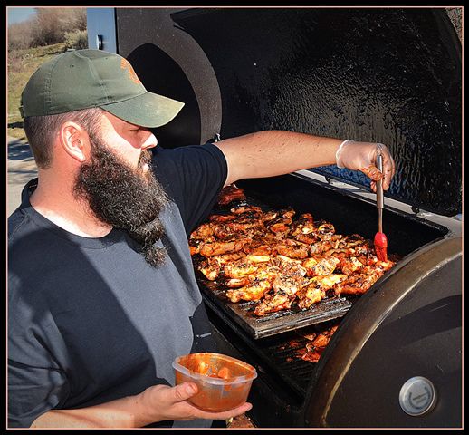 Stoney Bastes his Smoked Chicken Wings. Photo by Terry Allen.